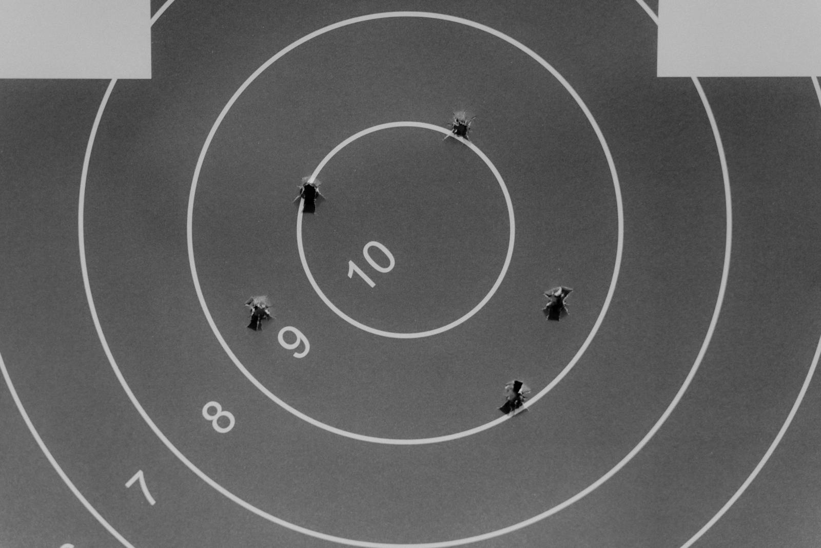 Black and white image of a shooting target with bullet holes.